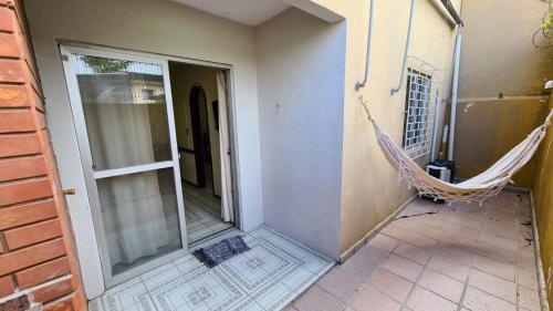 a hammock hanging on the side of a house at Apto a poucos metros do mar in Matinhos