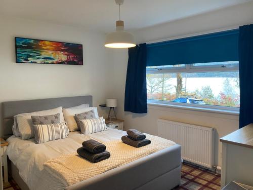 a bedroom with a bed with two towels on it at the waterside - carrick castle - loch goil in Carrick