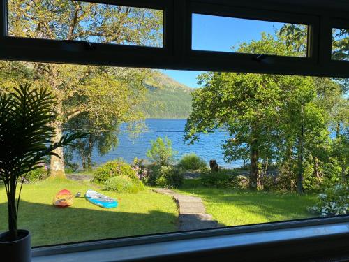 a view of a lake from a window at the waterside - carrick castle - loch goil in Carrick