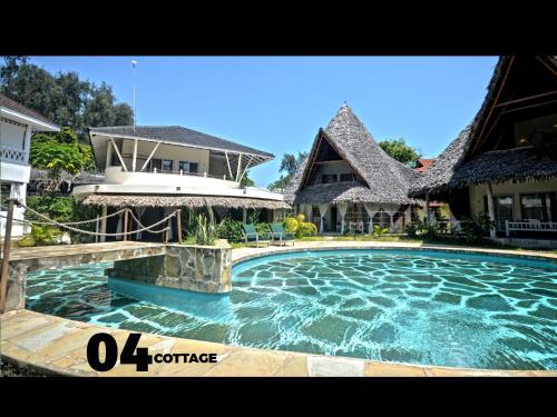 a swimming pool in front of a house at 04 beach cottage malindi in Malindi