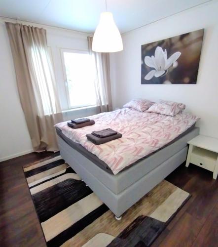a bedroom with a bed with pink sheets and a window at Ailo in Inari