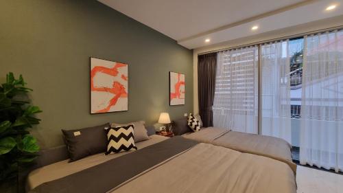 a bedroom with two beds and a large window at LaHomestay Hồng Hà in Hanoi