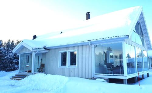 a small house with snow on the ground at Ailo in Inari