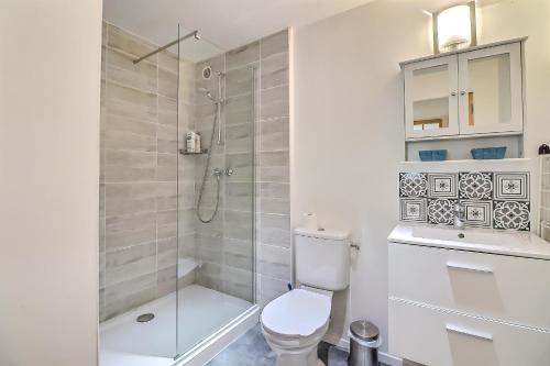 La salle de bains blanche est pourvue d'une douche et de toilettes. dans l'établissement Le carpe diem, appt à 10 min de Nîmes, à Bouillargues
