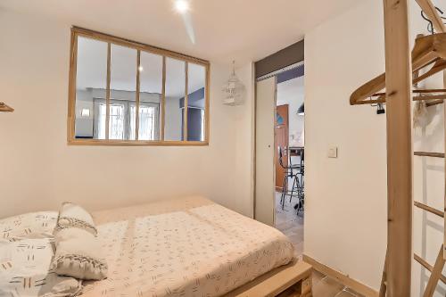 um quarto com uma cama e um espelho na parede em Le carpe diem, appt à 10 min de Nîmes em Bouillargues