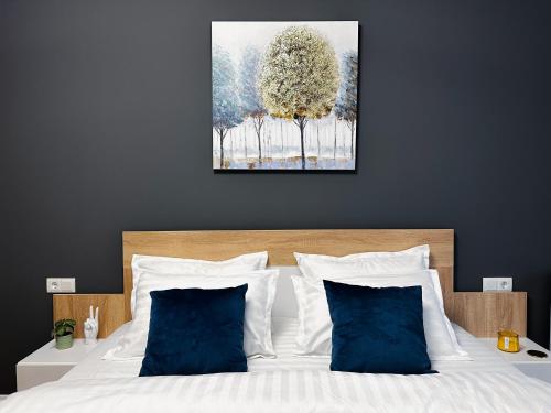 sypialnia z białym łóżkiem z niebieskimi poduszkami w obiekcie AD Apartments w Klużu-Napoce