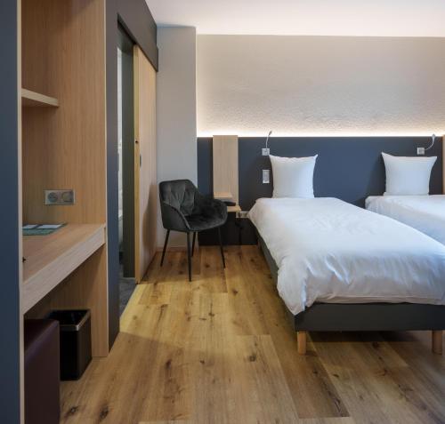 a bedroom with two beds and a desk and a chair at Logis Hôtel Restaurant Ritter'Hoft in Morsbronn-les-Bains