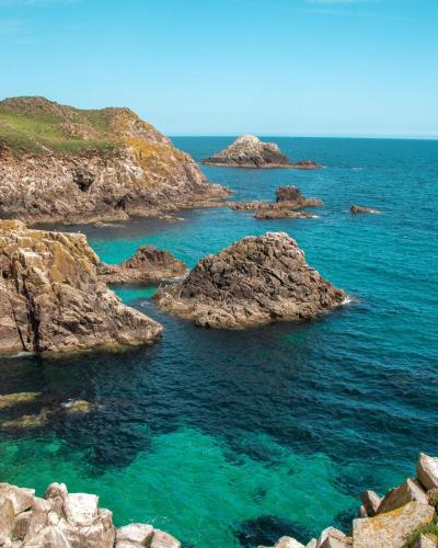 a group of rocks in the ocean with blue water at Ballyhack by the Sea in Arthurstown