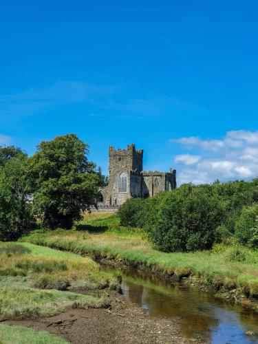 an old castle on a hill next to a river at Ballyhack by the Sea in Arthurstown