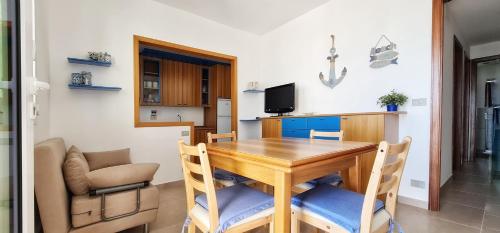 una sala da pranzo con tavolo e sedie in legno di Casa SantaBarbara a Marina di Ragusa