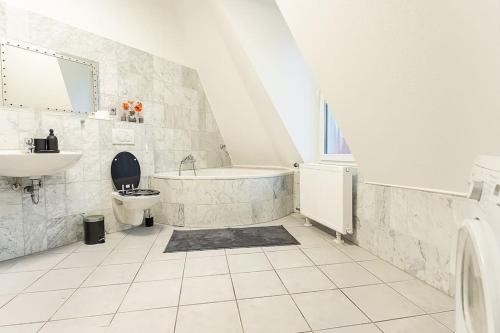 ein Badezimmer mit einer Badewanne, einem WC und einem Waschbecken in der Unterkunft Loft mit Billard-Tisch und PS4 in Wuppertal