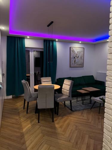 un soggiorno con un divano, un tavolo e delle sedie di Apartament Koliber Spa a Rzeszów