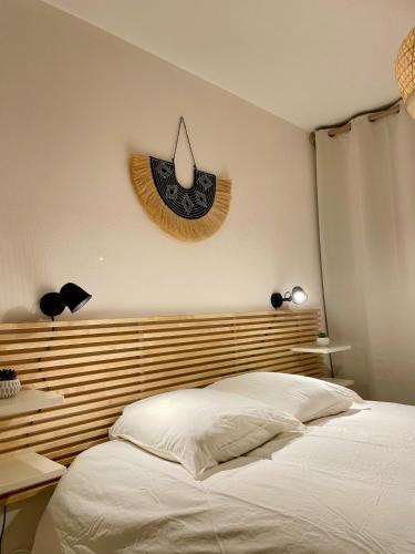 Un dormitorio con una cama y un reloj en la pared. en Grand studio Hyper centre WIFI, en Rodez