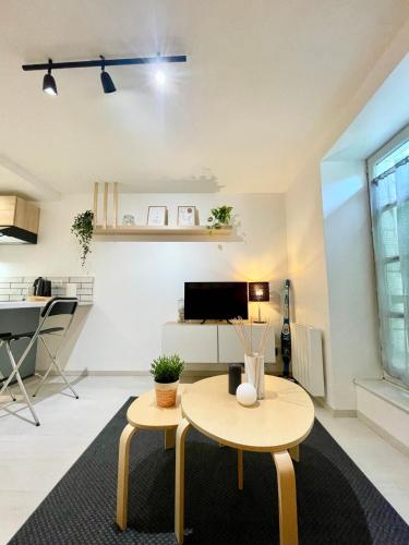 Una sala de estar con una mesa y un televisor. en Grand studio Hyper centre WIFI, en Rodez