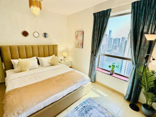 ein Schlafzimmer mit einem Bett und einem großen Fenster in der Unterkunft Luxury Casa - Indigo Sea View Apartment JBR Beach 2BR in Dubai