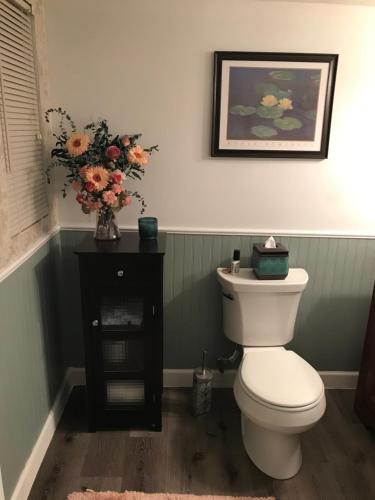 a bathroom with a toilet and a vase of flowers at Hope Bed and Breakfast in Canton