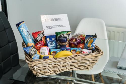 a basket of chips and snacks on a table at AMAZING CONTRACTOR HOUSE 3 bedroom warm modern house free secure off road parking, wifi & sky sleep upto 8 guest s in Aintree