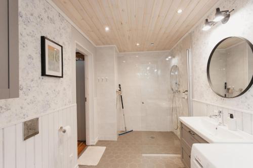 a bathroom with a shower and a sink and a mirror at Vase Holiday Home in Tartu