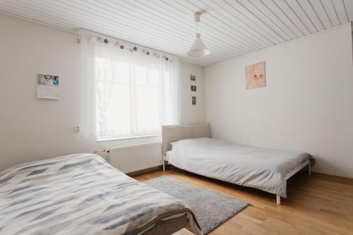 um quarto com uma cama e uma janela em Vase Holiday Home em Tartu