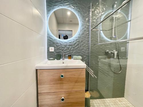 a bathroom with a sink and a shower with a mirror at Homelivia Av Jean Médecin in Nice