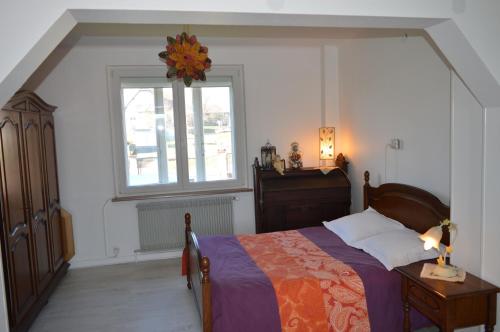 a bedroom with a bed and a window at Chez Thérèse et Marguerite in Kindwiller