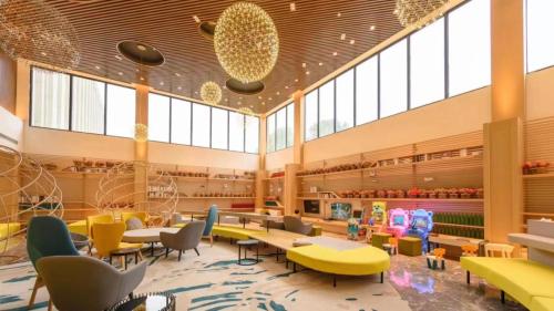 a cafeteria with tables and chairs and windows at Holiday Inn Shanghai Dishui Lake by IHG in Nanhui