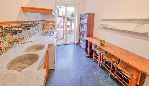 eine Küche mit 2 Waschbecken und einer Theke mit Stühlen in der Unterkunft L'uliveto di Santa con piscina in Santa Margherita Ligure