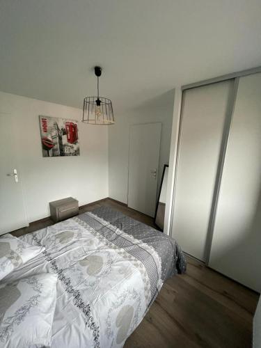 un dormitorio con una cama y una lámpara de araña en L'ALPIN, en Bourg-Saint-Maurice