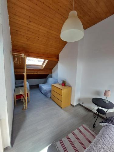 um quarto com uma cama, uma mesa e um tecto em Au cœur du vignoble sur Bursins em Bursins