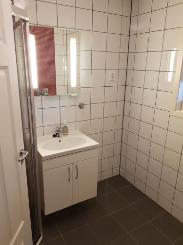 Baño blanco con lavabo y espejo en Fjærland Våteviksvegen 17, en Bøyum