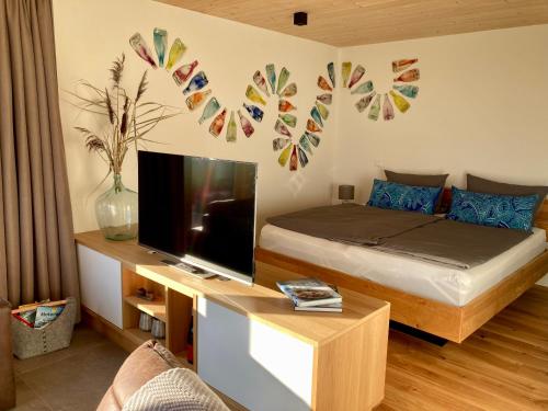 a bedroom with a bed and a television and a table at MoselHoch in Klüsserath