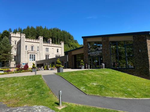 a large building with a green lawn in front of it at the waterside - carrick castle - loch goil in Carrick