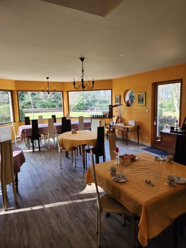 une salle à manger avec tables, chaises et fenêtres dans l'établissement Manoir de la Maison Blanche, à Amboise