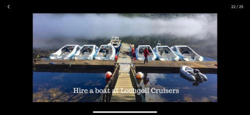 a group of boats parked at a dock on a lake at the waterside - carrick castle - loch goil in Carrick