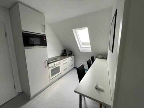 a kitchen with a white refrigerator and a table with chairs at Apartment Düte in Erpen