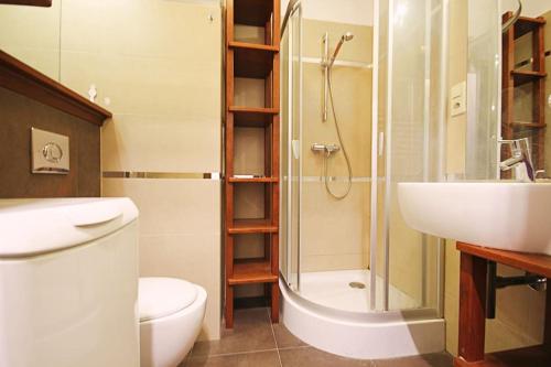 y baño con aseo, lavabo y ducha. en Parkowy Apartament, en Wroclaw