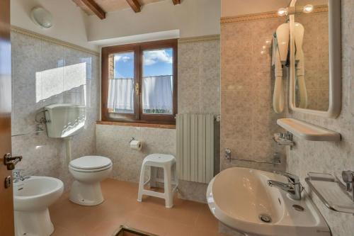 a bathroom with a toilet and a sink and a toilet istg at Tenuta Colombaio in Casole dʼElsa