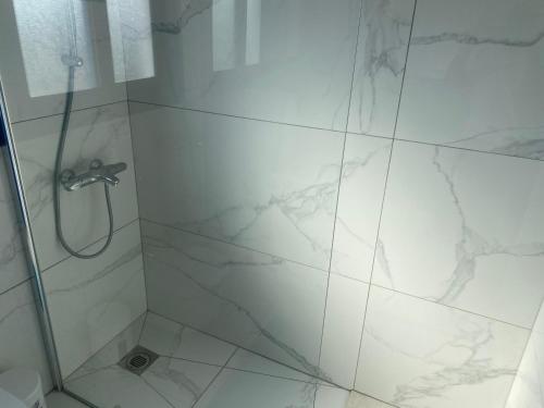a bathroom with a shower with white marble tiles at Olive Tree Villa - Protaras in Protaras
