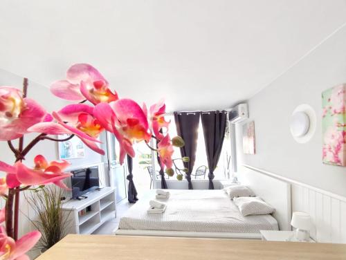 a room with two beds and pink orchids at Sunshine Borinquen in Playa de las Americas
