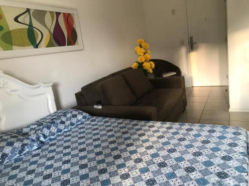 ein Schlafzimmer mit einer Couch und einem Bett und einer Couch in der Unterkunft Loft Reserva do Sahy - Mangaratiba in Mangaratiba