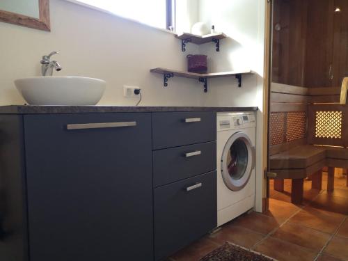 a bathroom with a sink and a washing machine at Metsaräägu Wellness 