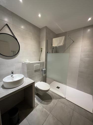 a bathroom with a sink and a toilet and a shower at Etesia in Feurs