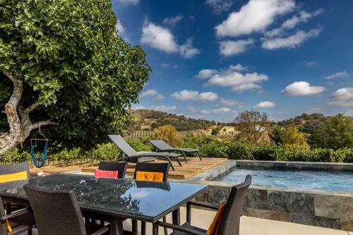 a patio with a table and chairs next to a swimming pool at Alojamentos Plansel - No Coração das Vinhas do Alentejo in Montemor-o-Novo
