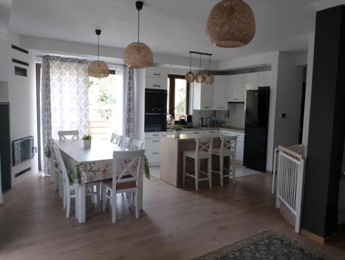 a kitchen and dining room with a table and chairs at Dom nad jeziorem - MAZURY in Szczytno