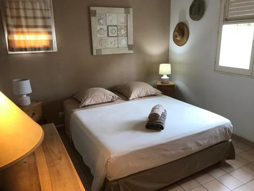 una camera da letto con un letto con una scarpa sopra di Maison Saint Exupéry a Le François