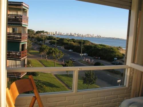 - une fenêtre avec vue sur la rue et l'océan dans l'établissement Apartamento en primera línea con vista al mar, à Punta del Este