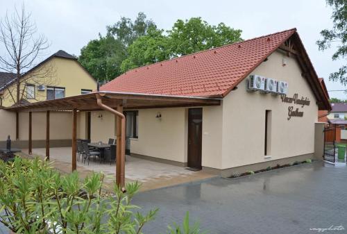 a house with a red roof and a patio at Vincze Vendeghaz in Kiskunhalas