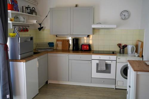 une cuisine avec des placards blancs et un comptoir dans l'établissement Ferienwohnung am Waldrand, Hitzacker, à Hitzacker