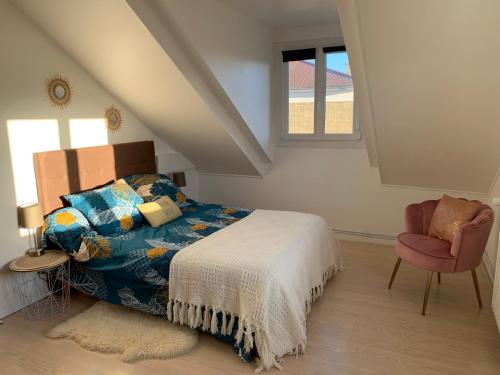 a bedroom with a bed and a chair at La maison parisienne & jardin in Argenteuil