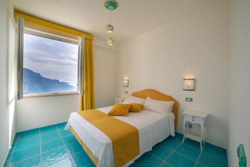 a bedroom with a bed and a large window at Ravello Dream Charming House in Scala